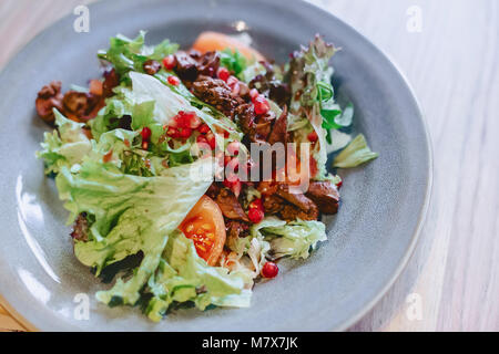 Foie et salade de grenades sur une plaque gris in cafe Banque D'Images