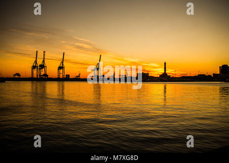 Silhouette de grues et Lanterna (PHARE) de la ville de Gênes (Genova), dans le port, au coucher du soleil, de l'Italie Banque D'Images