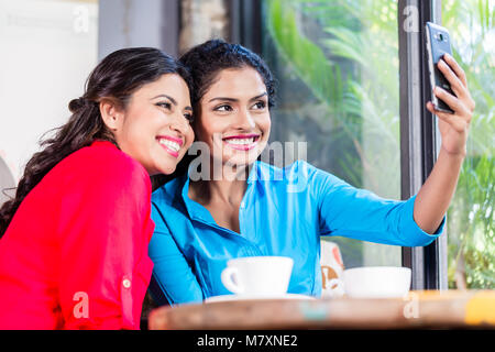 Les clients en prenant un café indien selfies Banque D'Images