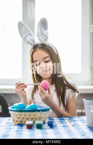 Cute little girl painting oeuf pour Pâques, closeup Banque D'Images