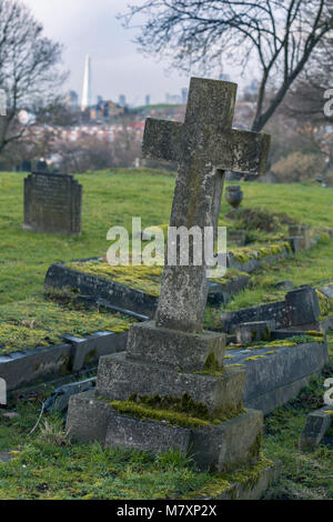 Londres, UK - JAN 2018 : Pierres tombales sur Camberwell cimetière dans le sud de Londres avec des gratte-ciel de ville en arrière-plan Banque D'Images