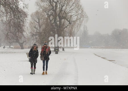 LONDON, UK : Deux jeunes femmes marchant en blanc Regent's Park alors qu'il neige Banque D'Images