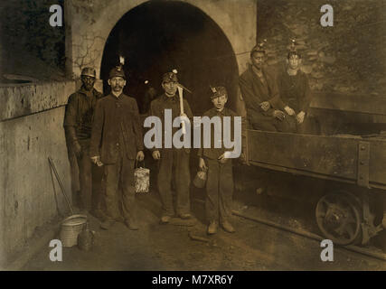 Les mineurs de charbon avec de jeunes garçon trappeur dans le centre, un portrait à l'entrée de la mine, Gary, West Virginia, USA, Lewis Hine pour Comité nationale sur le travail des enfants, Septembre 1908 Banque D'Images