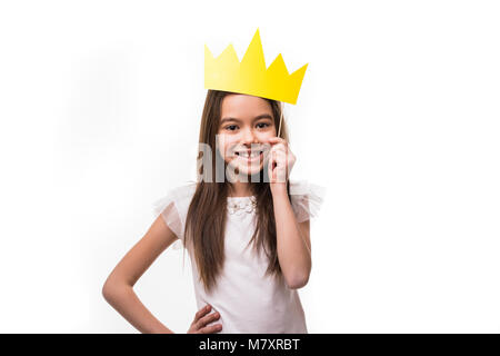 Mini Miss. Young happy girl avec un joli sourire rire portant une couronne sur fond blanc Banque D'Images