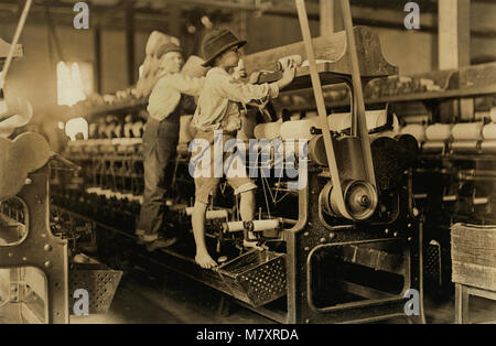 Deux jeunes garçons l'escalade sur le châssis de la filature de fils cassés et bobines vides, Bibb Mill n° 1, Macon, Georgia, USA, Lewis Hine pour Comité nationale sur le travail des enfants, Janvier 1909 Banque D'Images