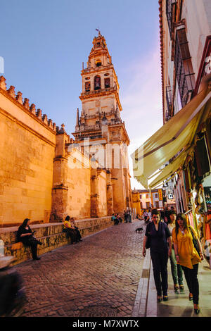 Cordoue, Andalousie, Espagne : les gens passent devant le clocher et façade nord de la mosquée-cathédrale de Cordoue au crépuscule. Banque D'Images