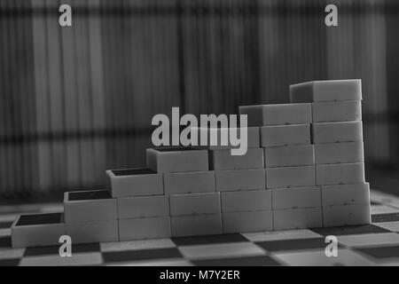 Pyramide monochrome de pièces domino sur la table en bois bambou brown background Banque D'Images