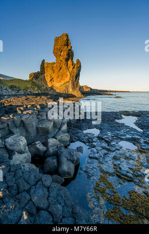 Mer Londrangar-cheminées volcaniques de basalte des digues, dans la distance, Glacier Snaefellsjokull, Péninsule de Snæfellsnes, l'ouest de l'Islande. Banque D'Images