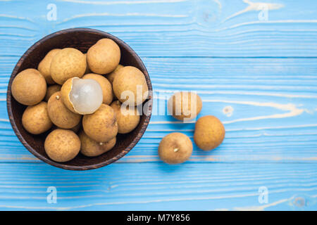 Close up de fruits tropicaux frais longane sur fond bleu planche en bois Banque D'Images