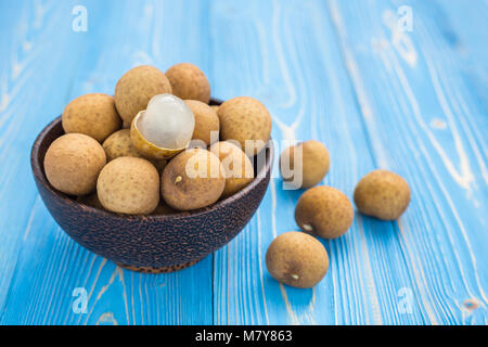 Close up de fruits tropicaux frais longane sur fond bleu planche en bois Banque D'Images