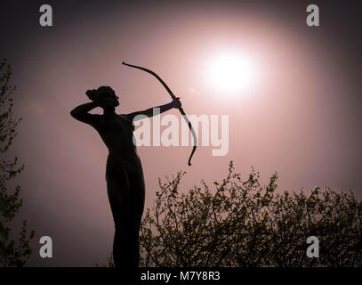 Statue de femme Silhouette Archer à l'arc cible le soleil Banque D'Images