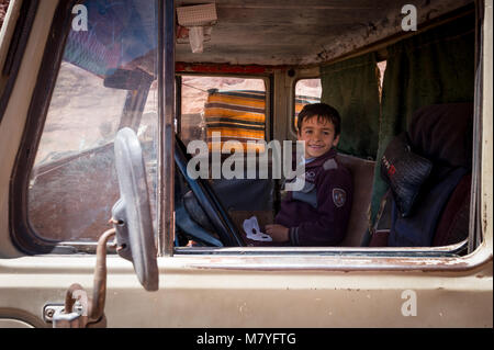 Jeune garçon Bédouin assis dans un vieux quatre roues motrices de Toyota dans le secteur de Wadi Rum en Jordanie. Banque D'Images