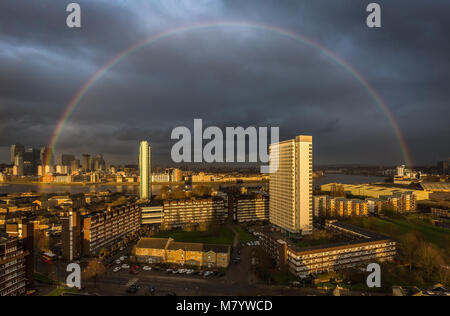 Londres, Royaume-Uni. 13 mars, 2018. Météo France : arc arc-en-ciel Massive ruptures dans la lumière du soleil du soir sur une sud-est de Londres. Le parc d'affaires de Canary Wharf bâtiments vus à gauche. © Guy Josse/Alamy Live News Banque D'Images