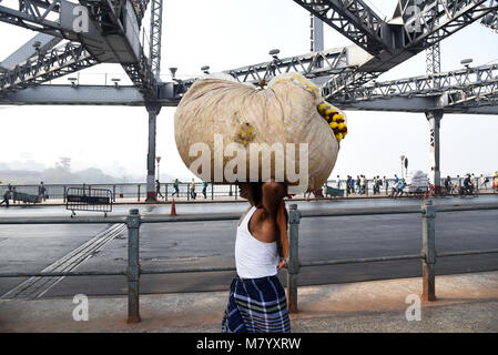 19 février 2018 - Kolkata, Bengale occidental, Inde - un homme vu le transport de marchandises sur le dessus de la tête sur le pont Howrah à Kolkata..La Rabindra Setu également connu sous le nom de Howrah Bridge est un pont à une travée suspendue sur la rivière Hooghly à Kolkata, qui a été commandée en 1943. (Crédit Image : © Tanmoy Bhaduri/SOPA des images à l'aide de Zuma sur le fil) Banque D'Images