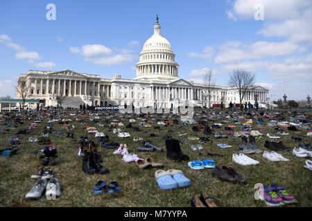 (180313) -- WASHINGTON, 13 mars 2018 (Xinhua) -- les chaussures représentant les enfants tués dans des fusillades en milieu scolaire depuis l'école élémentaire de Sandy Hook tournage en 2012 sont observés sur la pelouse devant le Capitole à Washington D.C., États-Unis, le 13 mars 2018. Un groupe d'activistes sur Mardi placé 7 000 paires de chaussures sur la pelouse en face du Congrès des États-Unis, pour protester contre l'inaction des législateurs face à de fréquentes fusillades en milieu scolaire dans le pays. (Xinhua/Yang Chenglin) Banque D'Images