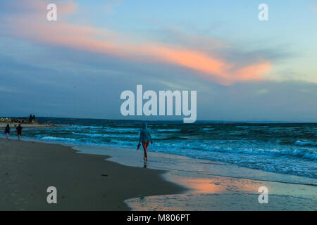 Adelaide Australie 14 mars 2018. Les gens qui marchent sur la plage pendant un coucher de soleil d'automne de la création avec de belles couleurs sur l'océan amer : Crédit ghazzal/Alamy Live News Banque D'Images