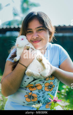 Fille est titulaire d'un mignon lapin outdoor Banque D'Images