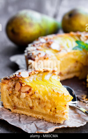 Délicieux gâteau avec demi-poires pochées et flocons d'amandes Banque D'Images