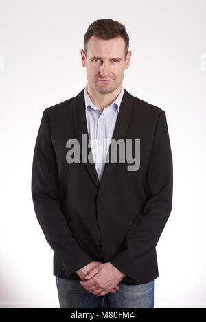 Jeune homme avec les mains jointes en stand black Jacket isolé sur fond blanc Banque D'Images