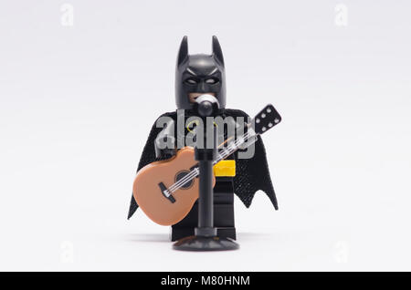 Lego Batman chantant et jouant une guitare isolé sur fond blanc. Banque D'Images