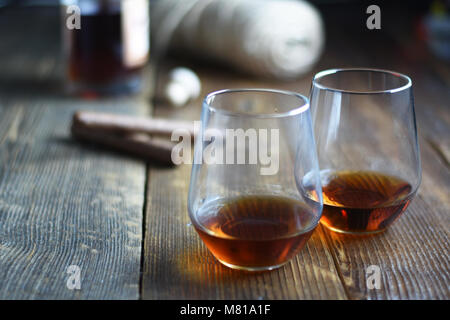 Outils de vintage verre de rhum sur une table en bois rustique avec des cigares et bouteille.barbier sur fond de bois Banque D'Images