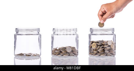 Thai baht (monnaie) en pot de verre clair avec différents niveaux de moins à plus. Studio shot isolé sur fond blanc. Économiser de l'argent ou d'investissement financi Banque D'Images