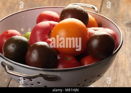 Les tomates dans une passoire sur une table rustique Banque D'Images