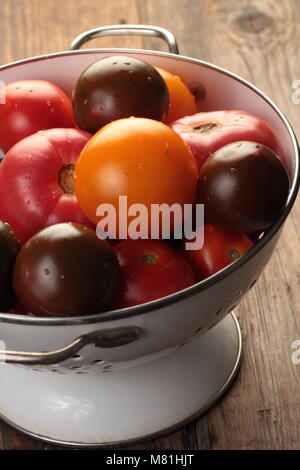 Les tomates dans une passoire sur une table rustique Banque D'Images