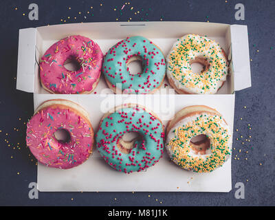 Donuts avec givrage coloré dans la boîte. Vue d'en haut Banque D'Images