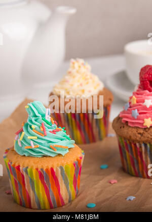 Des cupcakes avec glaçage coloré et des fruits avec du café Banque D'Images