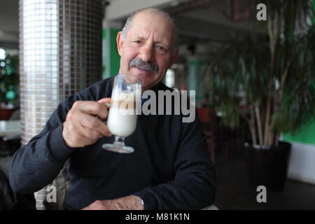 Senior man drinking latte dans un restaurant Banque D'Images