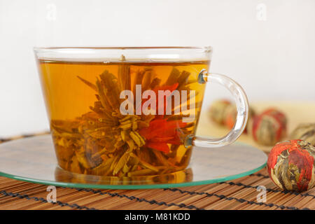 Tasse de thé vert avec fleur de lys rouge Banque D'Images