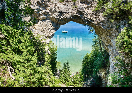 Trois bateaux sur le lac Huron sont amarrés ensemble sous Arch Rock sur l'île Mackinac, Michigan. Banque D'Images