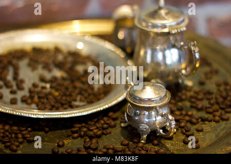 Les grains de café sur un plateau d'argent l'argent cafetière et tasses Banque D'Images