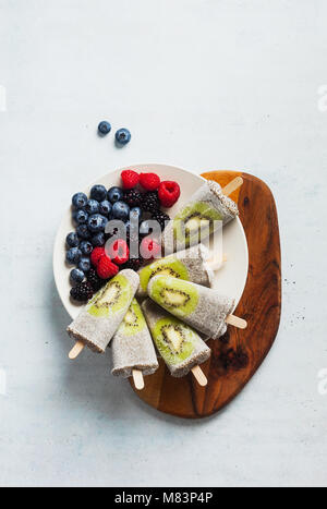Chia Noix de Coco kiwi frais mûrs Popsicles et baies sauvages le matin. table des bonbons sains Banque D'Images