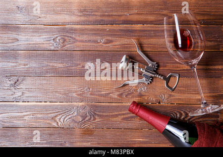 Photo de bouteille de vin, tire-bouchon, verre de vin, sur fond de bois brun. Banque D'Images