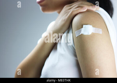Les femmes asiatiques a plâtre sur épaule après une injection du vaccin donnant Banque D'Images