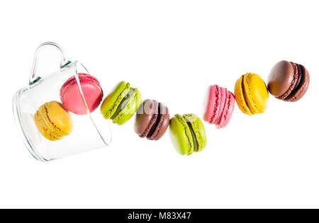 Berlingots colorés traditionnels macarons de la farine d'amande isolé sur blanc. et une tasse de thé vide. objets en mouvement Banque D'Images