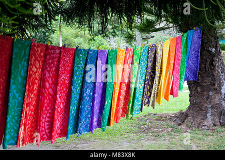 Couleurs de l'arc-en-ciel de couleurs vives, jusqu'à la pendaison matériau sec entre deux arbres dans le Pacifique sud de l'Île Cook. Banque D'Images