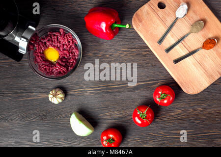 Still Life de hachoir à viande électrique, tomate, épices, oignon et paprika sur un fond de bois, télévision lay image avec l'emplacement pour un texte Banque D'Images