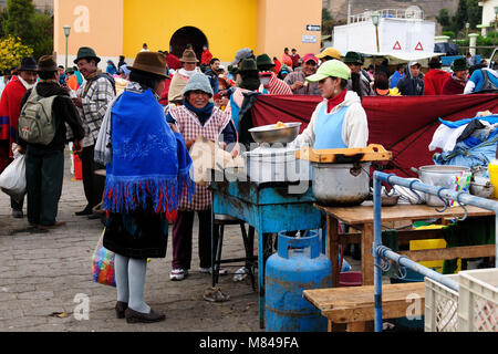 L'ÉQUATEUR, PUJILI - 11 août 2012 ; les vêtements femme équatorienne dans les aliments frais de vente sur un marché dans le village de Pujili Banque D'Images