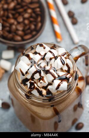 Café chocolat frappe avec des guimauves et le sirop dans un pot Mason . Selective focus Banque D'Images