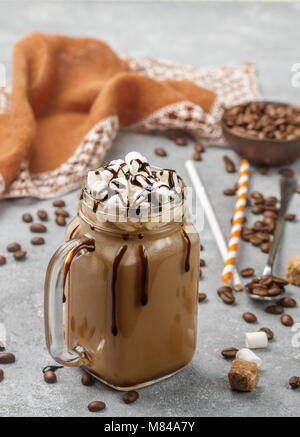 Café chocolat frappe avec des guimauves et le sirop dans un pot Mason . Selective focus Banque D'Images