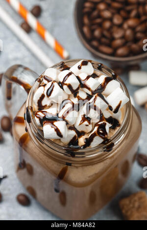 Café chocolat frappe avec des guimauves et le sirop dans un pot Mason . Selective focus Banque D'Images