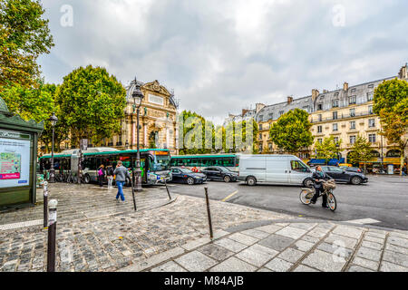 Un ciel nuageux, matin occupé dans la Place Saint-Michel dans le 5ème arrondissement de Paris en France avec la Fontaine Saint-Michel et bus, voitures et vélos Banque D'Images