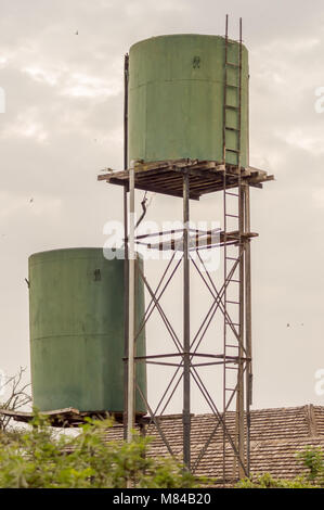 Deux réservoirs de stockage de l'eau verte sur pilotis dans la savane du Parc d'Amboseli au Kenya Banque D'Images