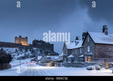 Château de Bamburgh et village de neige de l'hiver, Northumberland, Angleterre. L'hiver (février) 2018. Banque D'Images