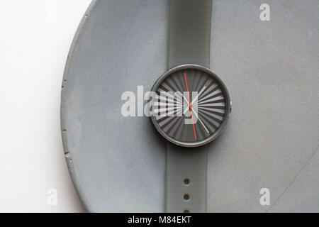 La relativité temps gris : montre-bracelet mécanique sans chiffres isolé sur une plaque de béton gris high angle view Banque D'Images