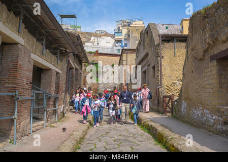 Voyage scolaire en Italie, une partie des élèves dirigé par leur professeur marche sur une rue romaine excavées à Herculanum, Baie de Naples, Italie. Banque D'Images