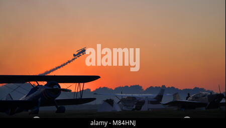 "Que le spectacle commence'. Le coucher du soleil un biplan vintage mène il nuit au cours de l'Airshow Tarkio 'Oreilles' aéronautique à Tarkio, MO. Banque D'Images